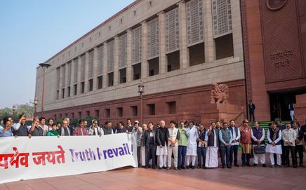 The Congress MPs hold posters bearing the slogan 